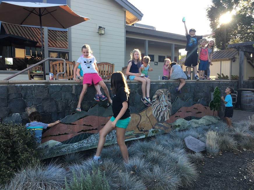 Kids climb on a stone wall in the evening sun