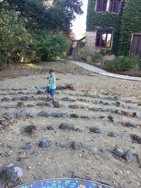 A small child runs through the rocks of the labyrinth