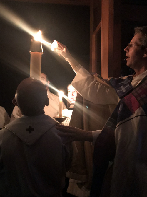 Lighting candles from the paschal candle to process into the church.